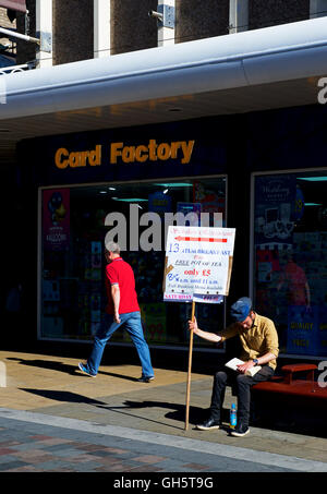 Young man holding up sign advertising breakfasts and a local café, Darlington, County Durham, England UK Stock Photo