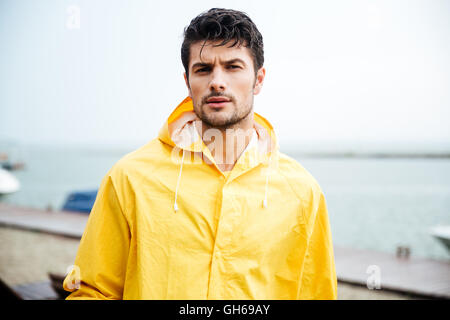 Close up portrait of a handsome young sailor man in yellow cloak Stock Photo