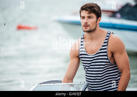 Young handsome bearded sailor man driving his motor boat Stock Photo