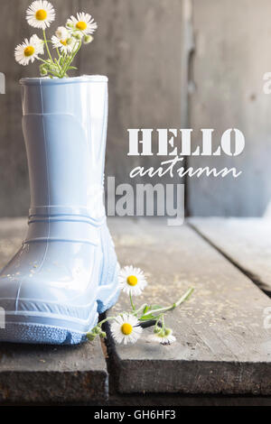 hello autumn text, daisy and boots on a old vintage table, Stock Photo