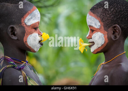 Young girl from Suri tribe playing with flowers. Stock Photo
