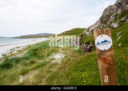 A waymarker sign for the Hebridean Way behind the beach at Coilleag a Phrionnsa on the island of Eriskay. Stock Photo