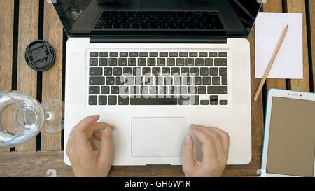 Person is typing on his laptop. Top view POV. Stock Photo