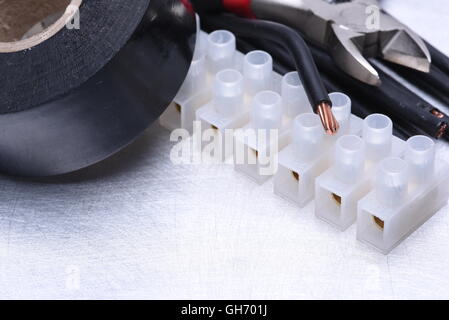 Electrical tools and component kit to use in electrical installations on grey metal background with place for text Stock Photo