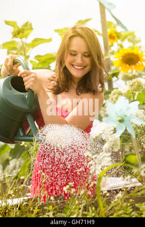 brunette woman watering plants in the garden Stock Photo