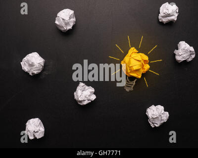 Crumpled paper on a chalkboard with a light bulb Stock Photo