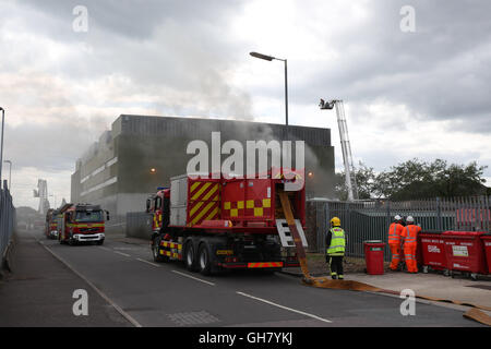 Marchwood, Hamphire, UK. 8th August 2016. Emergency crews from Hampshire fire and rescue service and South central  ambulance  service remain at the  cene of a  fire that broke out just after lunchtime today.  Fire crews have been brought from a far a field as Portsmouth to tackle the blaze at the fire at the recycling centre in East Road  Marchwood.  Eight fire engines two aerial ladders  and the incident command unit from Eastleigh been brought in to put out the fire out. Credit:  uknip/Alamy Live News Stock Photo