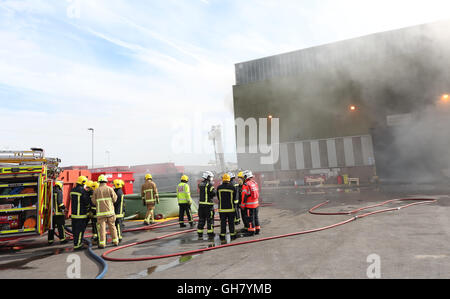 Marchwood, Hamphire, UK. 8th August 2016. Emergency crews from Hampshire fire and rescue service and South central  ambulance  service remain at the  cene of a  fire that broke out just after lunchtime today.  Fire crews have been brought from a far a field as Portsmouth to tackle the blaze at the fire at the recycling centre in East Road  Marchwood.  Eight fire engines two aerial ladders  and the incident command unit from Eastleigh been brought in to put out the fire out. Credit:  uknip/Alamy Live News Stock Photo