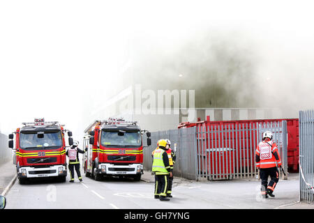 Marchwood, Hamphire, UK. 8th August 2016. Emergency crews from Hampshire fire and rescue service and South central  ambulance  service remain at the  cene of a  fire that broke out just after lunchtime today.  Fire crews have been brought from a far a field as Portsmouth to tackle the blaze at the fire at the recycling centre in East Road  Marchwood.  Eight fire engines two aerial ladders  and the incident command unit from Eastleigh been brought in to put out the fire out. Credit:  uknip/Alamy Live News Stock Photo