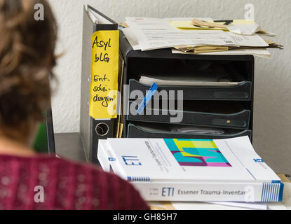 Hanover, Germany. 05th Aug, 2016. A binder written with 'asylum decisions' can be seen on a desk in an office from the Network for Traumatized Refugees in Lower Saxony behind the psychological questionnaire 'Essen Trauma Inventory' in Hanover, Germany, 05 August 2016. The Network for Traumatized Refugees in Lower Saxony sees to the urgent treatment and placement in psychological care for traumatized refugees. Photo: SEBASTIAN GOLLNOW/dpa/Alamy Live News Stock Photo