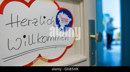 Hanover, Germany. 05th Aug, 2016. A sign written with 'welcome' and 'refugees welcome' hangs on an open door at the Network for Traumatized Refugees in Lower Saxony in Hanover, Germany, 05 August 2016. The Network for Traumatized Refugees in Lower Saxony sees to the urgent treatment and placement in psychological care for traumatized refugees. Photo: SEBASTIAN GOLLNOW/dpa/Alamy Live News Stock Photo