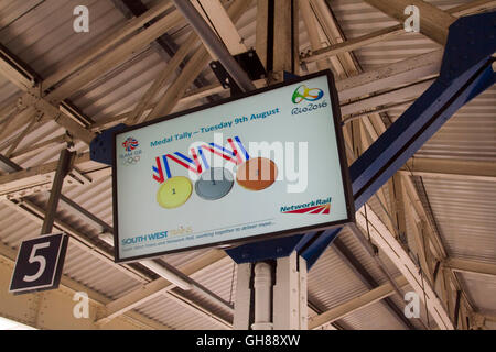 London, UK. 9th August 2016. Commuters walk under an electronic board at Wimbledon station advertising Team GB medal tally at the Rio 2016 Olympics Credit:  amer ghazzal/Alamy Live News Stock Photo