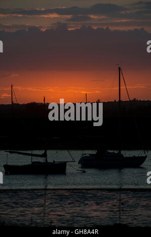 West Mersea, Essex, UK. 9th August, 2016. UK Weather: The sun goes down behind Yachts at anchor in West Mersea on the River Blackwater in Essex. Andrew O'Brien/Alamy Live News Stock Photo