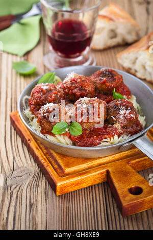 Homemade meatball made with ground beef and marinara sauce with Italian pasta in  frying pan  on rustic wooden table Stock Photo