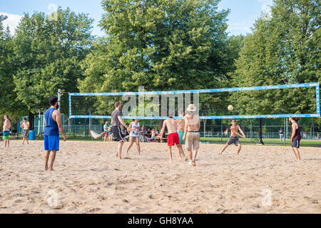 Summertime in Montreal, Canada - People are having fun playing volleyball in Lafontaine Park. Stock Photo