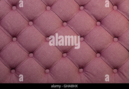 Pink capitone textile background, retro Chesterfield style checkered soft tufted fabric furniture decoration with buttons, close Stock Photo
