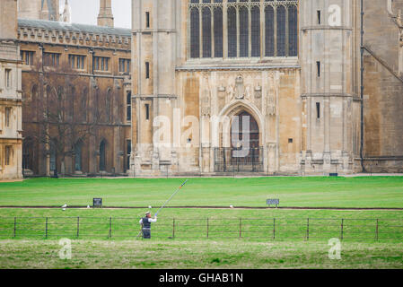 On the River Cam a man pilots his punt past the west front of King's College Chapel, Cambridge, UK. Stock Photo