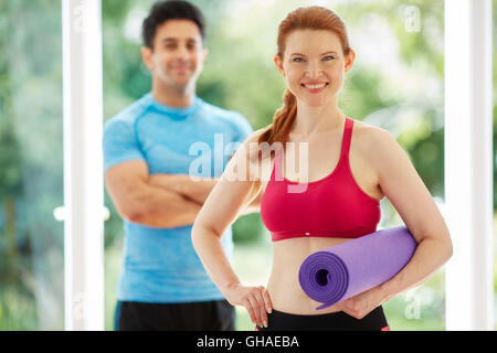 Couple stood together in gym Stock Photo