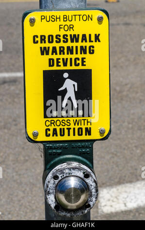 A sign and button to activate the sequence for safer pedestrian street crossing. Stock Photo