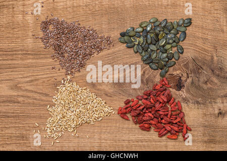 Goji berries, oats, linseed, pumpkinseed on wooden background. Healthy superfoods. Clean eating. Detox. Food concept Stock Photo