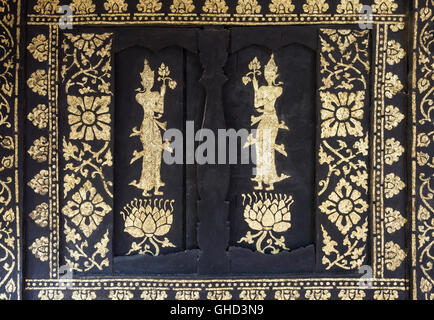 Golden angel painting with the flower pattern on the old wooden window of Thai temple,(Public area not required Property Release Stock Photo
