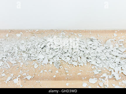 White concrete scrap on the laminate flooring from the drilling wall . Stock Photo