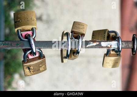 Brass padlocks & metal locks secured on a steel railing  in Lisbon Portugal Stock Photo