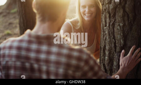 Playful couple at tree in woods Stock Photo