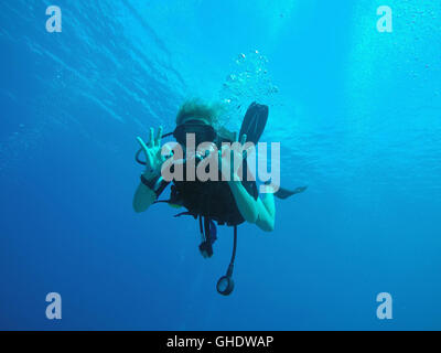 Portrait of confident scuba diver gesturing okay underwater Stock Photo