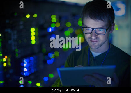 Server room technician using digital tablet Stock Photo