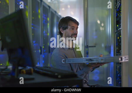 Server room technician removing rack from cabinet panel Stock Photo