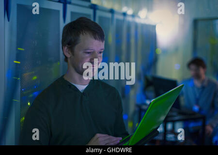 Server room technician using laptop Stock Photo