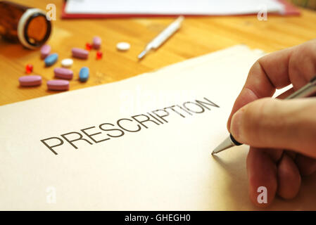 Doctor's hand writing prescription, close up with selective focus Stock Photo