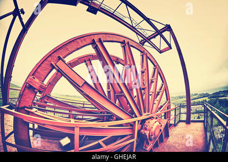 Vintage stylized fisheye lens photo of a mine shaft pulley wheel. Industrial detail background. Stock Photo