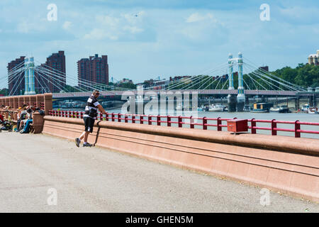 A man stands on the Embankment, overlooking the river Thames, next to Battersea Park in central London. Stock Photo