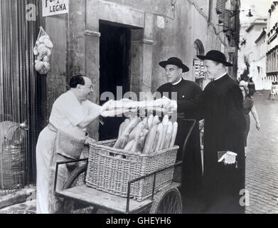 WHEN IN ROME USA 1952 Clarence Brown PAUL DOUGLAS (Joe Brewster) and VAN JOHNSON (Father John X. Halligan) buying bread in an alleyway in Rome. Regie: Clarence Brown Stock Photo