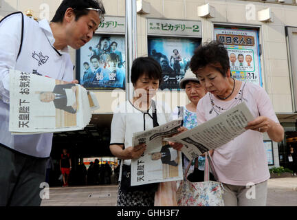 Tokyo, Japan. 8th Aug, 2016. People read extra edition newspapers which report Japanese Emperor Akihito's message to public in Tokyo on Monday, August 8, 2016. The 82-year-old Emperor indicated to his readiness to abdicate in the video message. © Yoshio Tsunoda/AFLO/Alamy Live News Stock Photo