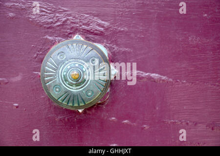 Closeup of antique brass door knob with patina green color with a vivid purple background. Stock Photo