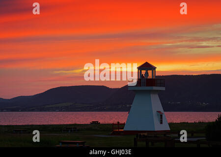 A fiery sunset behind the lighthouse at Carleton in Gaspesie, Quebec, Canada Stock Photo
