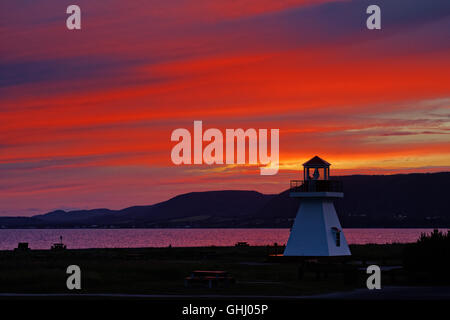 A fiery sunset behind the lighthouse at Carleton in Gaspesie, Quebec, Canada Stock Photo