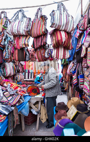 Pisac, Peru - May 15: Peruvian man selling souvenirs like handbags and hats at the market in Pisac. May 15 2016, Pisac Peru. Stock Photo