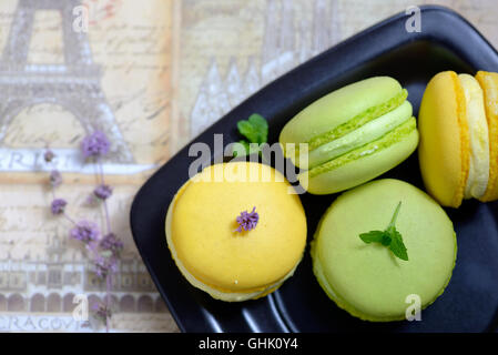 Lemon and mint flavor french macarons on black plate Stock Photo