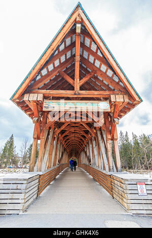 Family walks across Kicking Horse Pedestrian Bridge over the Kicking Horse River in the town of Kicking Horse, BC, Canada. Stock Photo