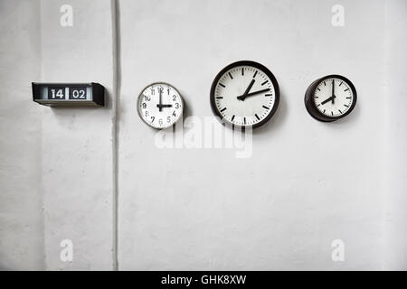 Clocks on a white wall, time passing concept, space for text. Stock Photo