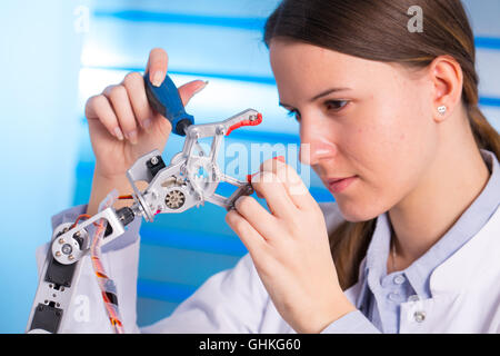 Young woman technician repair roboter manipulator Stock Photo