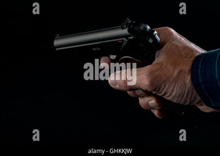Gun in man hand on pink background Stock Photo