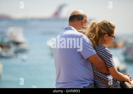 A Middle Aged Couple Embrace By The Waterfront In Avalon, Catalina Island. Stock Photo