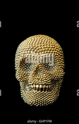 Ornate smiling gold human skull on pure black background Stock Photo
