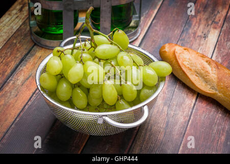 Fresh grapes in stainless steel colander on a wood surface Stock Photo
