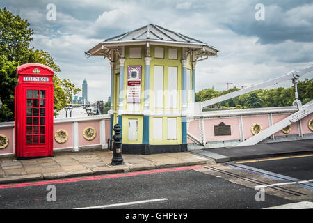 A red London telephone kiosk and tollbooth on Albert Bridge, Chelsea, London, England, UK Stock Photo